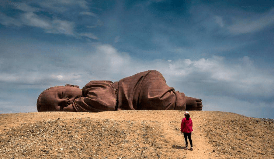 原创 甘肃沙漠创意雕塑，“巨婴”趴在沙漠三年，游客：看着让人心疼1